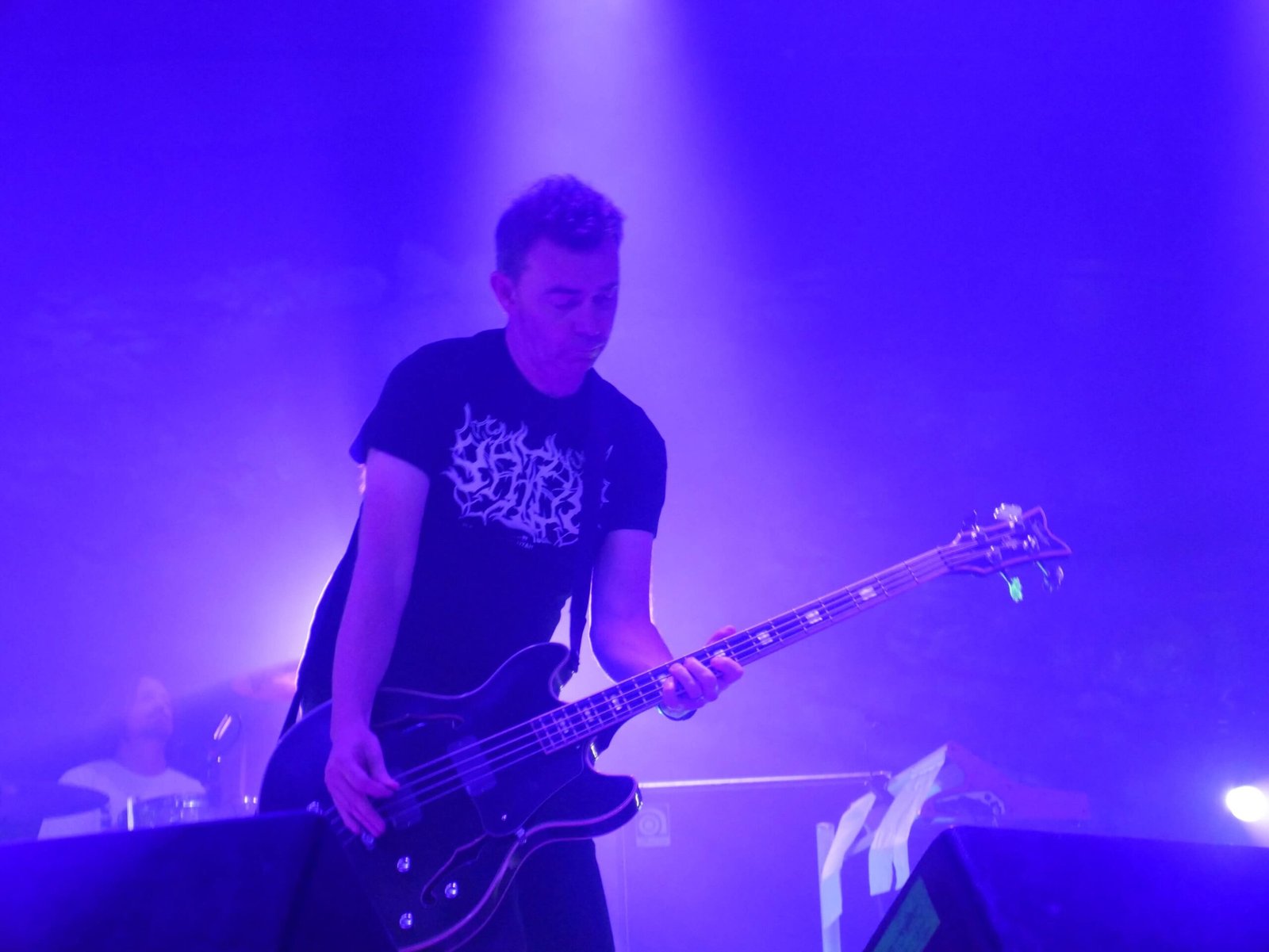 slowdive bassist playing in blue light on stage at the caverns